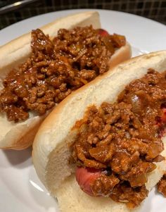 two hot dogs on buns covered in chili