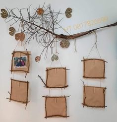 several pieces of fabric hanging on a wall with leaves and branches attached to them,