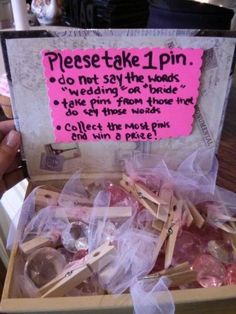 a box filled with lots of food on top of a wooden table next to a pink sign