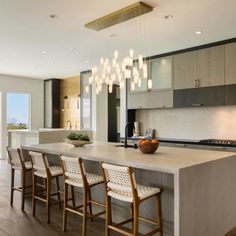 a modern kitchen with an island and bar stools