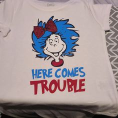 a t - shirt that says here comes trouble with a cat in the hat on it