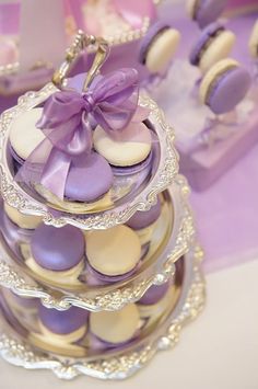 purple and white macaroons are stacked on top of each other with a bow