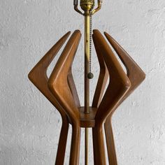 a lamp that is on top of a wooden stand with a clock in the middle