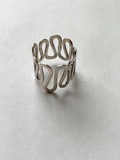 This is a very fun vintage retro sterling silver wavy band ring. The ring is a size 7. It is Hallmark sterling. It has a makers mark of the letter X. At the widest point the ring measures approximately three-quarter inches. This item is an excellent preowned vintage condition with normal wear for the age Letter X, Rings Statement, Makers Mark, Sterling Silber, Band Ring, Vintage Sterling Silver, Three Quarter, Band Rings, Statement Rings