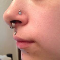 a woman with piercings on her nose and nose ring in front of her face