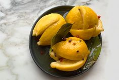 some lemons are on a plate with green leaves