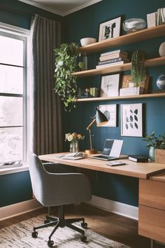 a home office with blue walls and wooden shelves on the wall, along with a desk