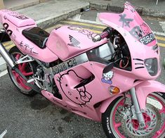 a pink hello kitty motorcycle parked on the street