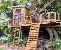 a tree house built into the side of a tree with stairs leading up to it