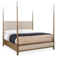 a bed that is made up with four posts and pillows on the headboard, in front of a white background