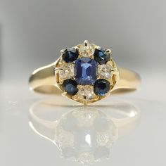 a blue and white diamond ring sitting on top of a table