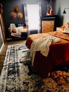 a bed room with a neatly made bed and a rug on the floor next to it