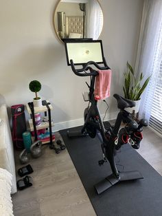 an exercise bike in the corner of a room with a mirror on the wall above it