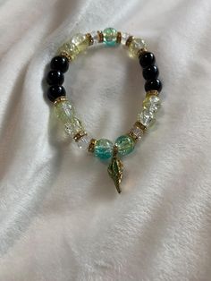 A green crystal beaded bracelet with a seashell charm. Cheap Green Beaded Charm Bracelet, Cheap Green Bracelet, Cheap Green Beaded Bracelets With Charms, Cheap Green Bracelets, Sea Bracelet, Crystal Beads Bracelet, Green Sea, Green Crystal, Green Crystals