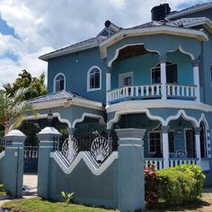 a blue house with white trim and balconies