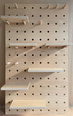 large wooden pegboard finish in oak with wooden shelves and solid pegs Wood Peg Wall, Storage Wood Shelves, Peg Board Shelving, Large Hole Pegboard, Birch Plywood Shelves, Large Pegboard Wall, Birch Plywood Walls, Wall Storage Office, Peg Board Organization