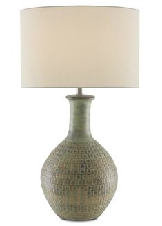 a green vase with a white shade on it and a light in the middle that is turned on