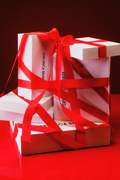 two white boxes with red ribbons tied around them