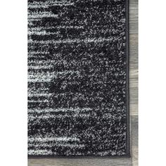 a black and white rug on top of a wooden floor