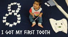 a little boy sitting on top of a blue blanket next to toothbrushes and other items