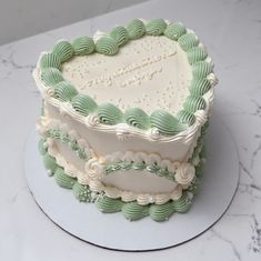 a heart shaped cake sitting on top of a white plate next to a marble counter