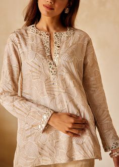 The tunic embodies a relaxed fit top with a plunging neckline with detailed mirrorwork and beadwork. V-neck Embellished Kurta For Wedding, V-neck Kaftan With Embroidered Neckline For Festive, Festive V-neck Kaftan With Embroidered Neckline, Embellished V-neck Kurta For Party, Festive Embellished Straight Kurta Top, Elegant V-neck Kurta With Resham Embroidery, Festive Embellished V-neck Kaftan, Festive V-neck Hand Embellished Kaftan, Traditional Festive Embellished Tunic