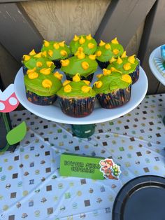 cupcakes with green frosting and yellow flowers on them sitting on a table