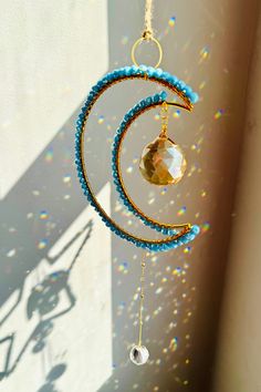 a wind chime hanging from the side of a wall with beads and crystals on it