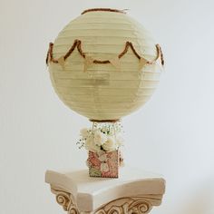 a paper lantern sitting on top of a table next to a vase filled with flowers