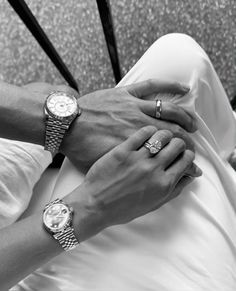 two people holding hands while standing next to each other with watches on their wrists