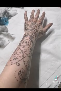 a person's arm with tattoos on it and one hand holding the other up