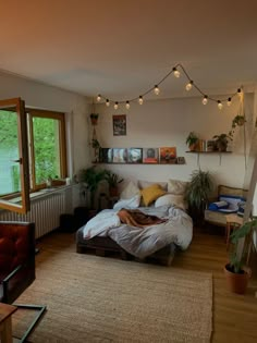 a bed room with a neatly made bed and lots of lights hanging from the ceiling