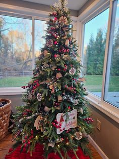 a decorated christmas tree in front of a window