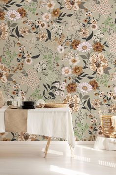 a table with a white cloth on it next to a floral wallpaper