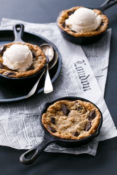 two small cast iron skillets with ice cream and chocolate chip pies in them