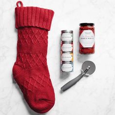 a red sock, jar of jam and spoon on a white countertop next to it