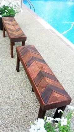 two wooden benches sitting next to a swimming pool