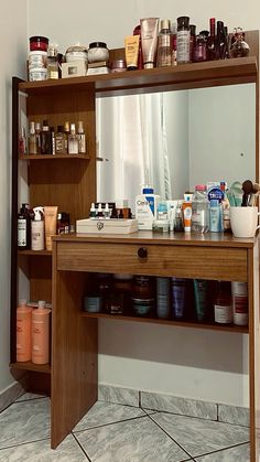 a wooden shelf filled with lots of personal care items next to a bathroom sink and mirror