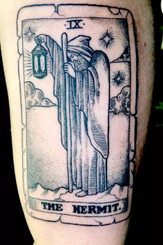 the hermit tarot card tattoo on someone's leg, it looks like he is holding