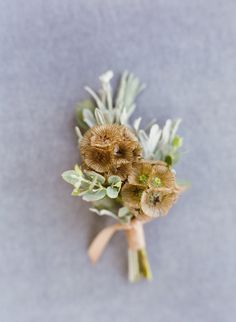 a bunch of flowers that are on top of a white surface with a brown ribbon