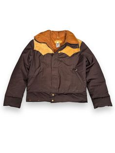 You've seen the vests but how about a full jacket. This Vintage Brown & Orange Rocky Mountain Featherbed Down Jacket comes with a plastic YKK zip and despite a stain or two lower on the jacket that will most likely come out with a minor wash, it's in good vintage condition and sure to keep you warm and stylish on the slopes.       Marked Size: 40 Chest: 48" Sleeves: 26" Shoulders: 19" Length: 26.5" Item is for sale at Barn Owl Vintage Goods in Georgetown. Seattle's Home for Vintage Rocky Mountain Featherbed Co Down Jackets!  Every attempt has been made to document every flaw, but we are, alas, human so there exists the possibility we have not gotten everything.  All sales are final.  No refunds or exchanges. Fitted Brown Outerwear For Outdoor, Retro Fall Biker Jacket For Outdoor, Retro Biker Jacket For Fall Outdoor, Retro Biker Jacket For Fall, Fitted Brown Outerwear With Padded Collar, Vintage Winter Biker Jacket With Snap Buttons, Vintage Biker Jacket With Snap Buttons For Winter, Fitted Vintage Outdoor Outerwear, Vintage Fitted Outerwear With Padded Collar