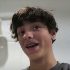 a close up of a person with a toothbrush in his mouth and an object in the background