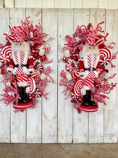 two red and white christmas wreaths with candy canes on them against a wooden wall