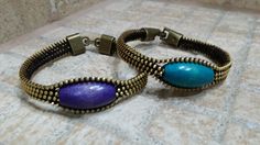 two bracelets sitting on top of a tile floor