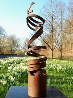 a metal sculpture sitting on top of a green field