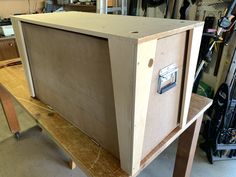 a wooden cabinet sitting on top of a piece of plywood