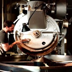 a man standing in front of a machine with food on it's pans