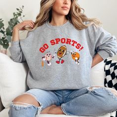 This Go Sports! sweatshirt is the perfect addition for the sports fan in your life. The retro graphic is sure to be a conversation starter and will put a smile on everyone's face. Whether you're lounging at home or catching the game, this sweatshirt is the perfect blend of comfort and style. Get yours today and add a touch of fun to your wardrobe! Gildan 18000 Crewneck unisex sweatshirt True to size, size up for oversized fit. Please check the size chart in photos. 50% cotton, 50% polyester Mach Sporty College Sweatshirt For Football Season, Sports Sweatshirt, Sportswear Crew Neck T-shirt For Football Season, Game Day Football Season Sportswear Top, Sports Graphic Print Crew Neck Sweatshirt, Sportswear Tops For Game Day During Football Season, Sportswear Tops For Football Season Game Day, Athletic Heather Fan Apparel Sweatshirt For Sports Season, College Sports Season Sweatshirt With Logo Print