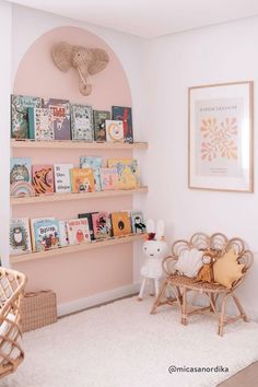 a baby's room with pink walls and bookshelves on the shelves in front of them