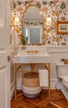 a white sink sitting under a mirror in a bathroom next to a toilet and vanity